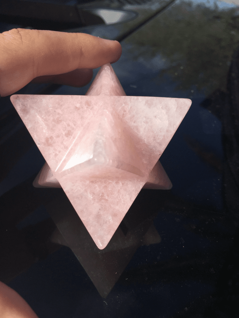 A hand holding an object in the shape of a star.